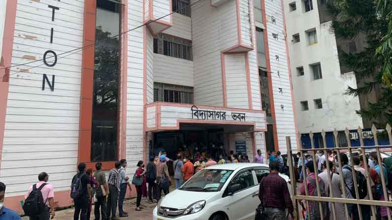 অনুত্তীর্ণ ছাত্রছাত্রীর তালিকা নিয়ে সংসদ ভবনে  স্কুলের হেড মাষ্টার মশাইদের লম্বা লাইন। গরমে সকলে ক্লান্ত, বিব্রত।